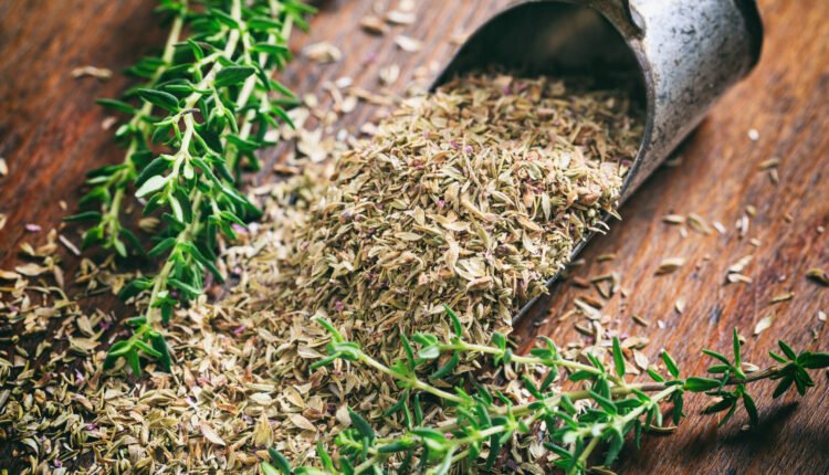 Fresh and dried thyme on a wooden table