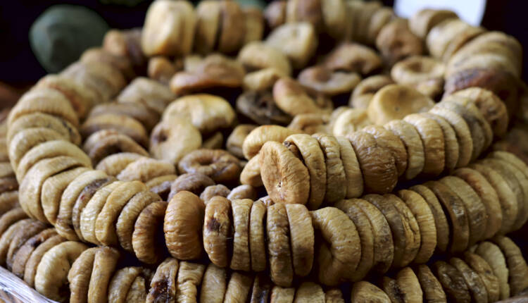 Dried figs stacked in rows in a circle on a market window. Cropped shot, horizontal, close-up, side view. The concept of agriculture and nutrition.