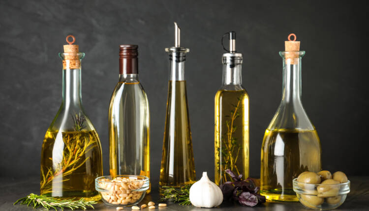 Composition with different sorts of cooking oil on grey table